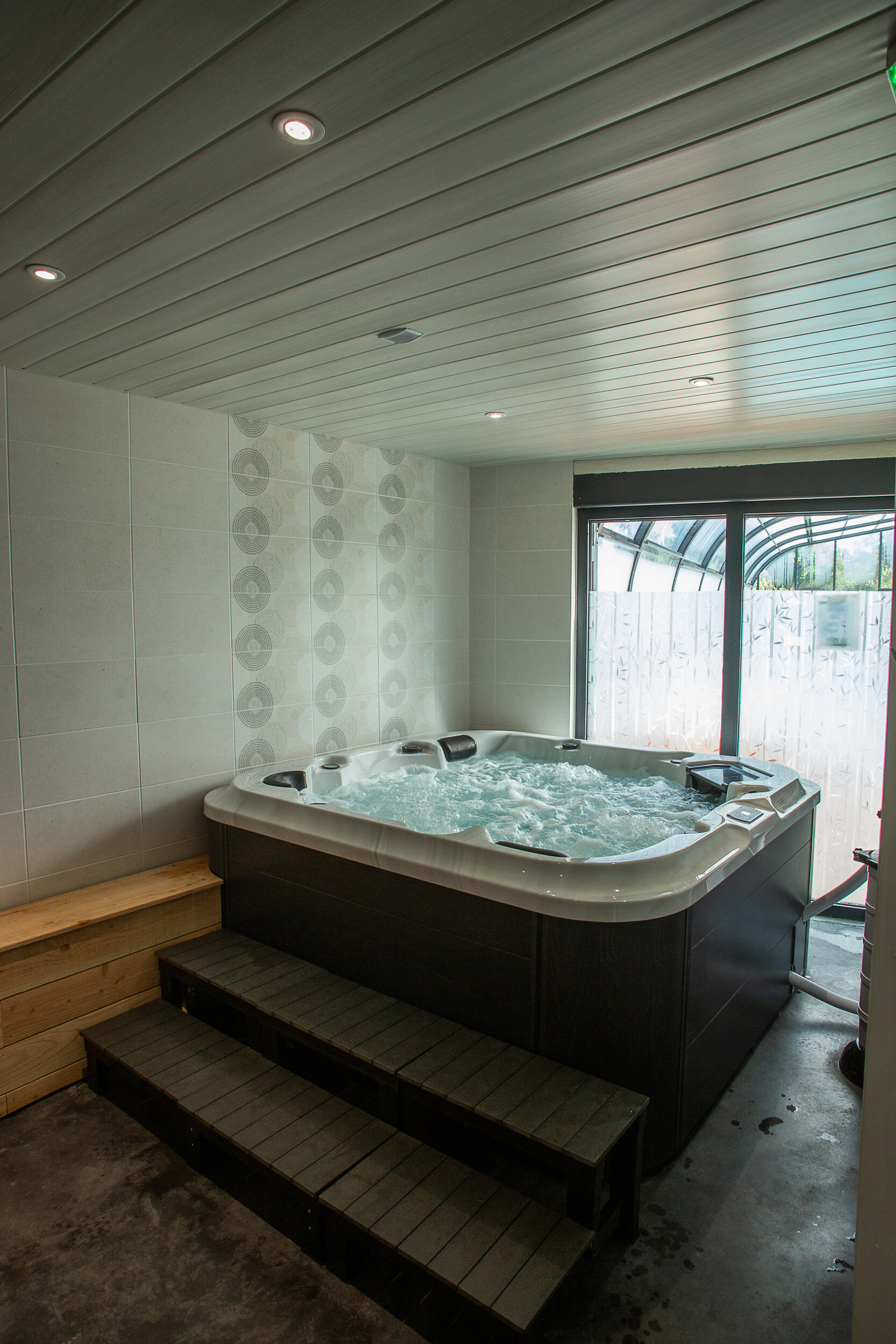 Vue d'ensemble du jacuzzi et de l'espace détente du camping au lac de Paladru
